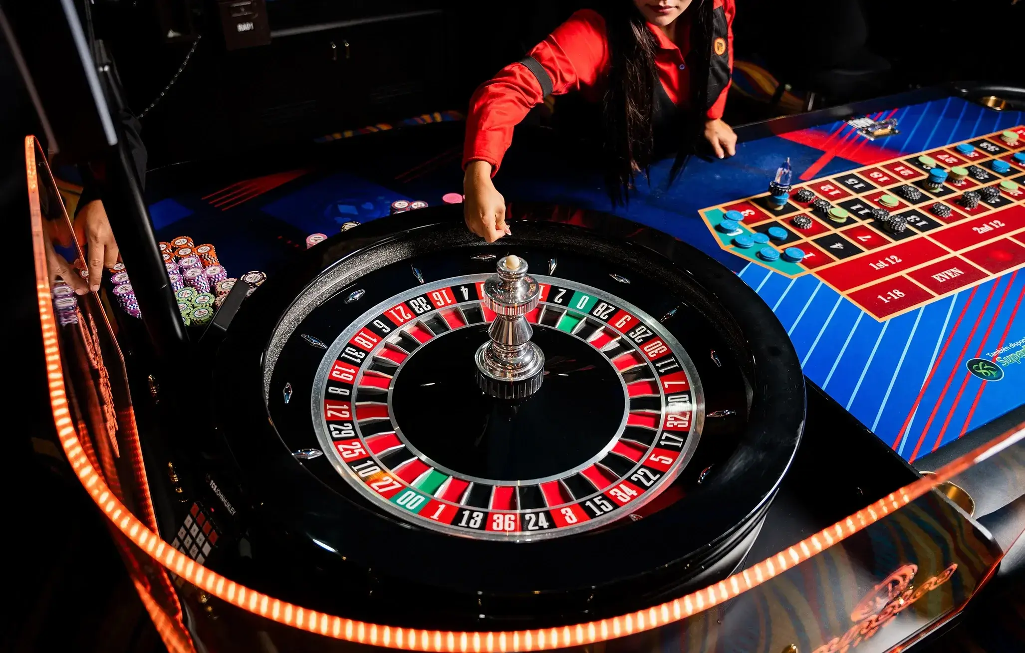 Mesa de ruleta con fichas y rueda iluminada en Maunaloa